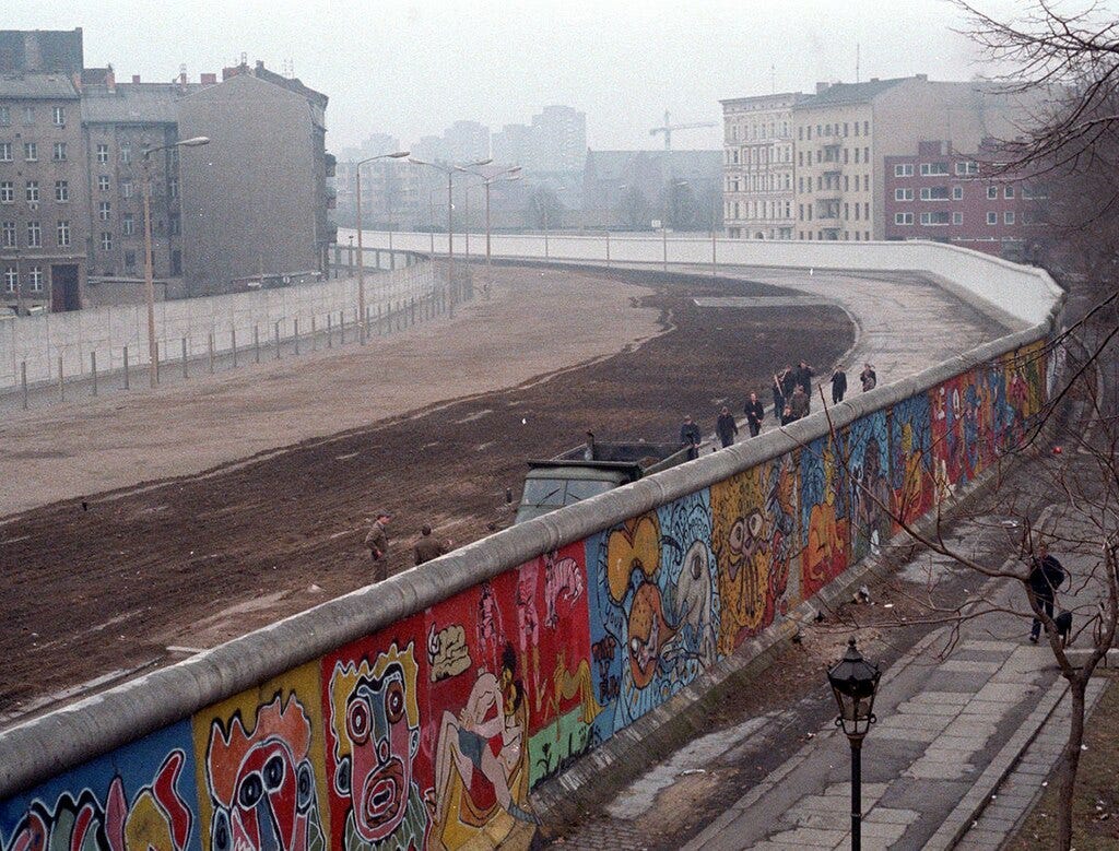 The Berlin Wall viewed from the Western side, with no-man's land and the Eastern Wall visible on the left.