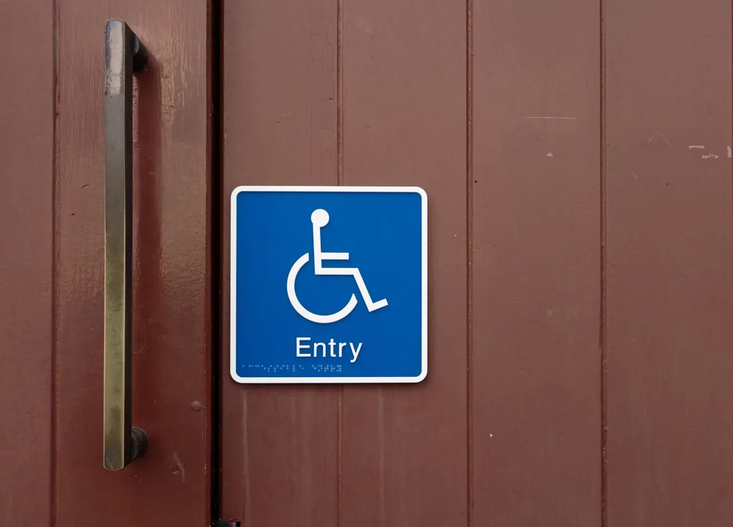 Door with blue wheelchair symbol sign marked "Entry"