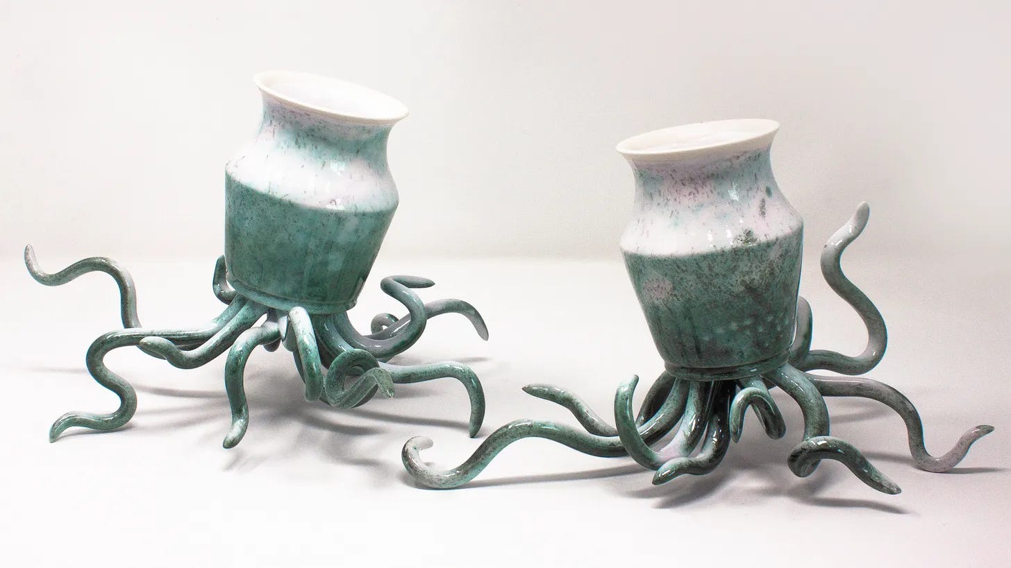 Deux petits vases émaillés dans des teintes turquoise, qui reposent sur des tentacules qui semblent être en mouvement