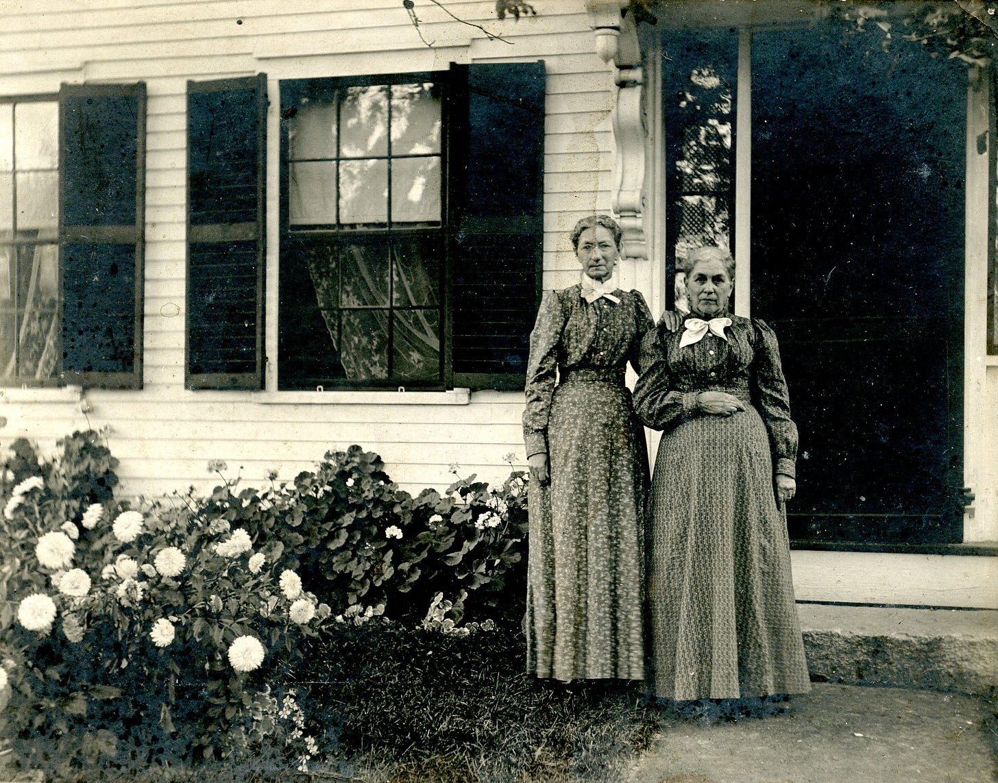 Two women standing outside the house