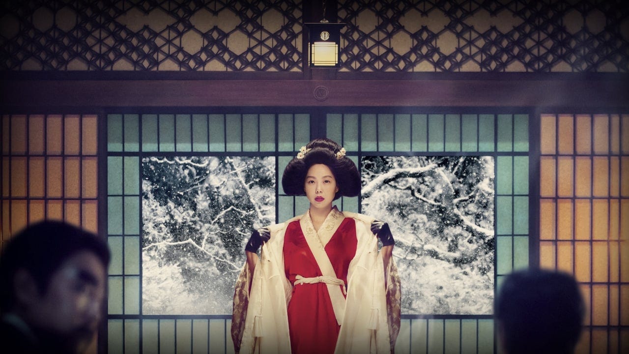 Movie still from The Handmaiden. A woman in 1930s Japanese occupied Korea stands in traditional robes before some sitting men.