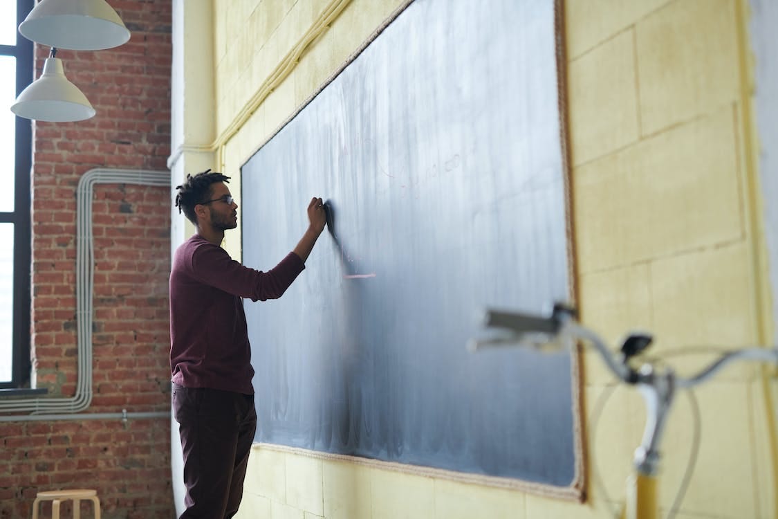 Free Man Writing on a Blackboard Stock Photo