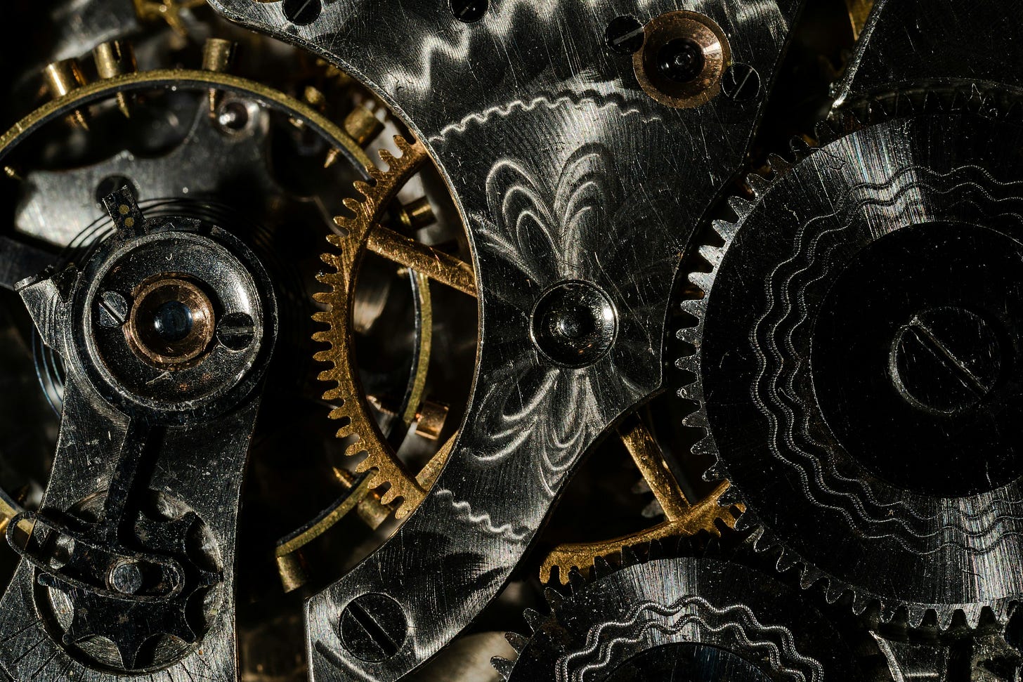 A detail-rich photo of interlocking gears on some kind of mechanism.  The gears are gold and silver.