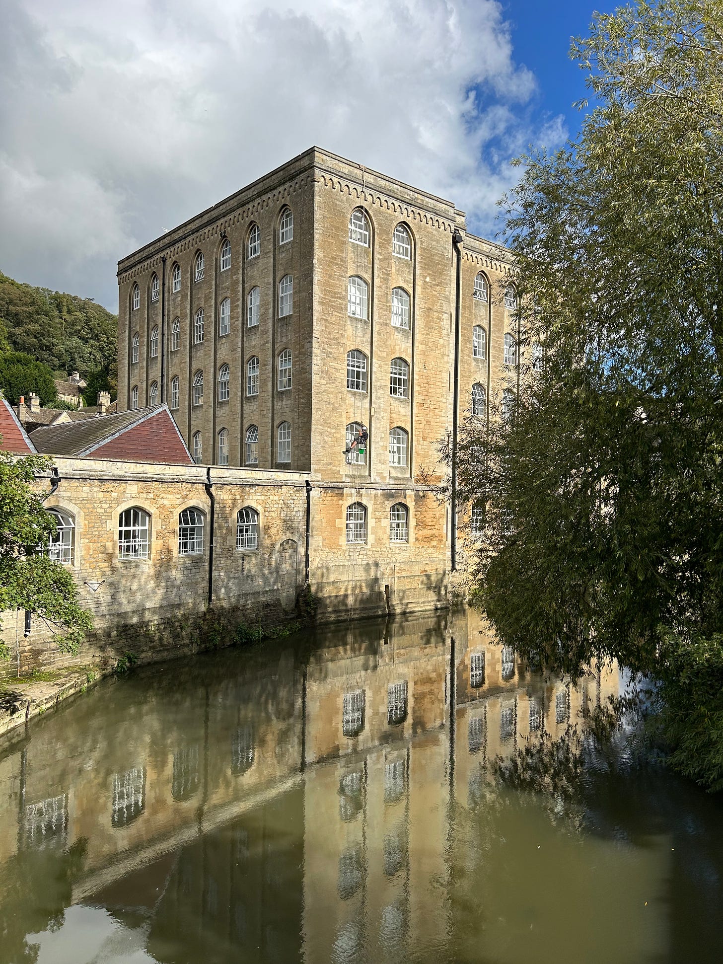 A window cleaner abseils down the side of Abbey Mill, Bradford on Avon, Wiltshire. Image: Roland's Travels