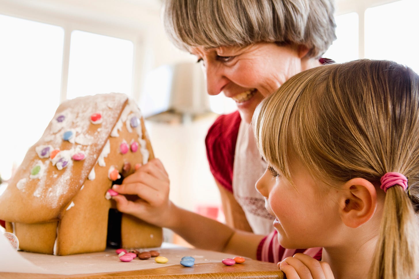 Grandma and granddaughter making a gingerbread house. (Getty Images)