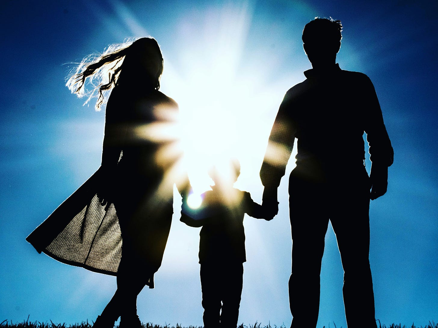 man woman child holding hands outdoors