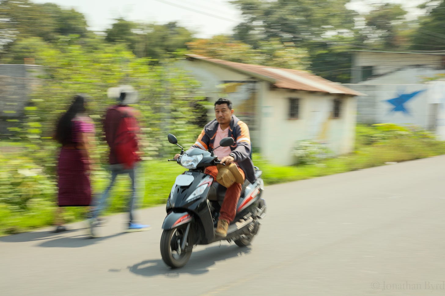 a motorcyle speeds down a road in Guatemala