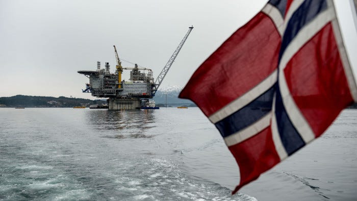 A Norwegian national flag flies from the back of a boat in view of the the Aasta Hansteen gas platform operated by Statoil ASA during its ceremonial baptism near Stord, Norway, on Thursday, March 8, 2018. Oil companies operating in Norway raised investment forecasts for this year after a wave of projects were approved, and expect spending to rise for the first time since crude prices collapsed in 2014. Photographer: Carina Johansen/Bloomberg