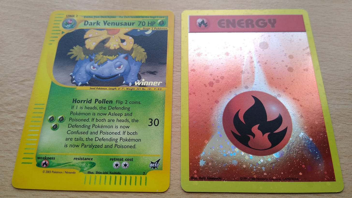 The two cards I won in the Pokéschool contest: a Winner Stamped Dark Venusaur promo card and a Holo Fire Energy Pokémon League promo card