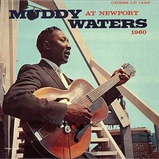 Muddy Waters holds a hollowbody electric guitar on the cover of his album, At Newport 1960