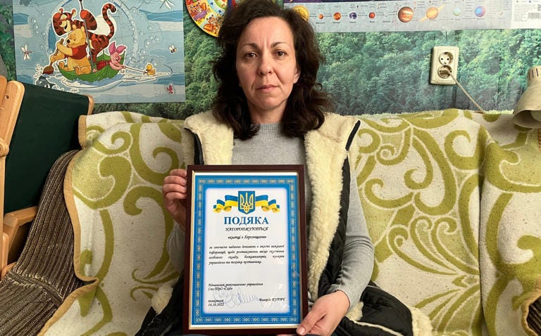 Irina Kabycheva, who spied on Russian troops while out walking with her son, holds a cerficate of congratulation she received from Ukraine's armed forces - Colin Freeman for The Telegraph
