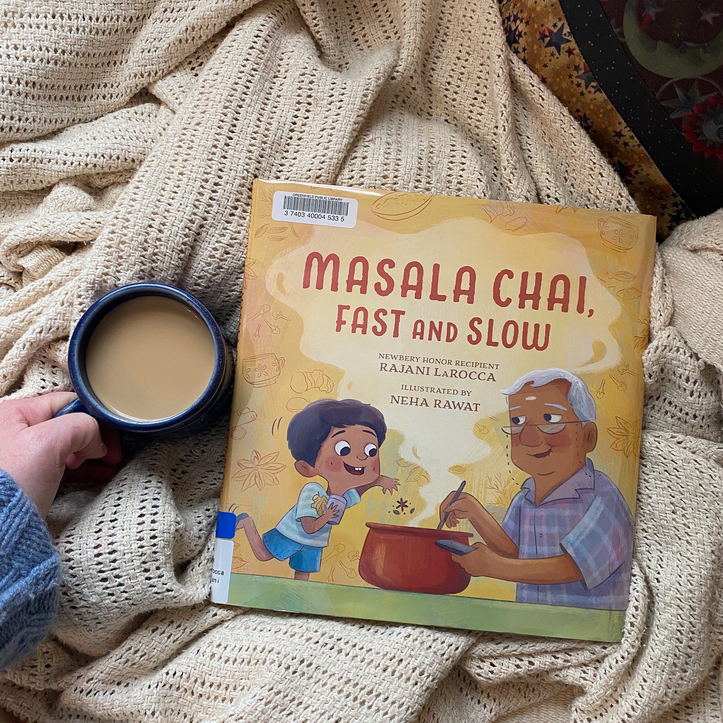 Masala Chai, Fast and Slow, on a white blanket next to a mug of chai.