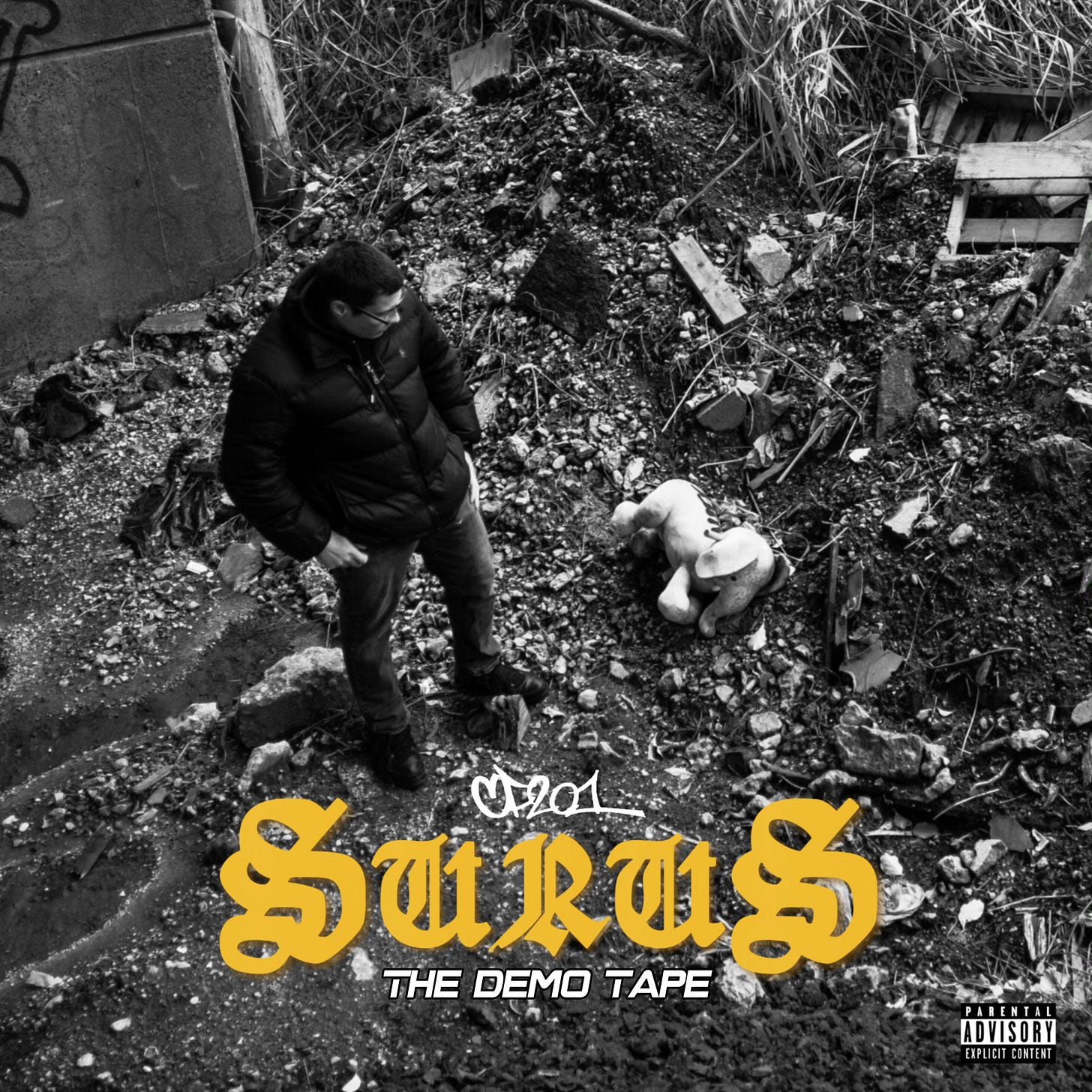 Cover of album "SURUS" from rapper Constant Flow. Image is a black and white photo of the rapper in a waste-strewn area of the Palisades (a range of cliffs) in Jersey City. Standing in a parka and looking down, the rapper, a stocky male, looks down at a discarded stuff elephant. Below both is the title "SURUS" in yellow. Its subtitled "The Demo Tape"