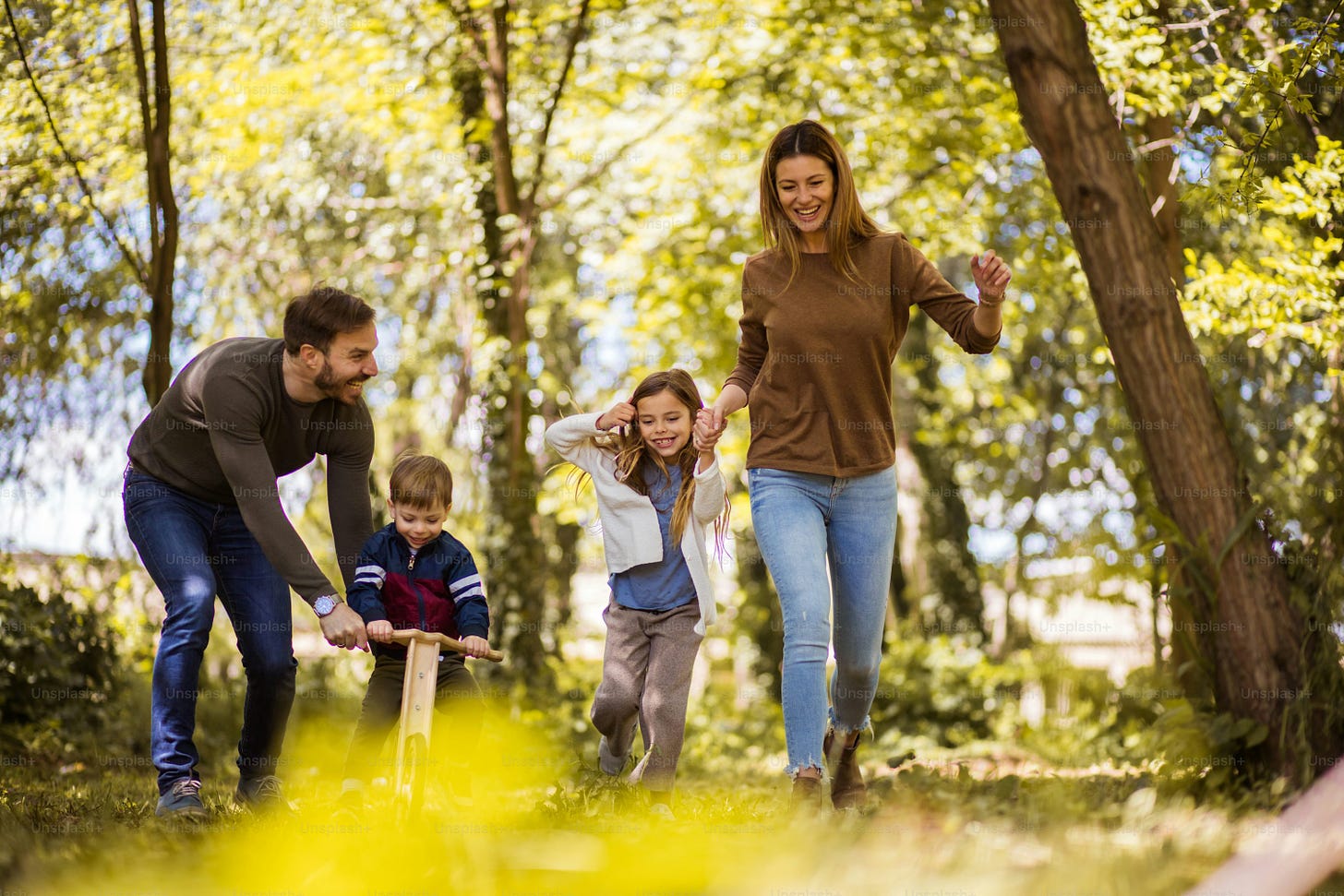 Making time for the family. Parents spending time with their children  outside. photo – Outdoors Image on Unsplash