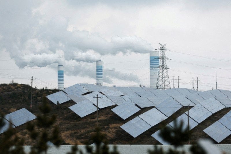 Smoke rises from chimneys near solar panels in Shaanxi