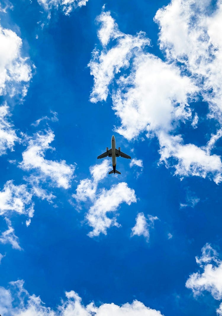 Plane flying across a blue sky.