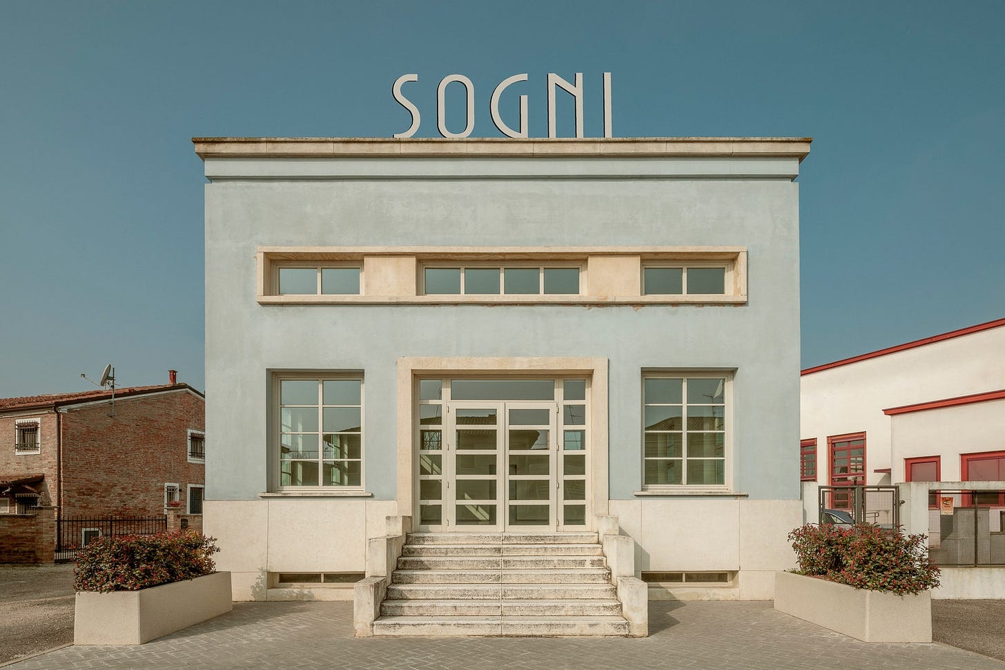 Tresigallo Edificio azzurro con scala centrale finestre e la scritta Sogni in cima.