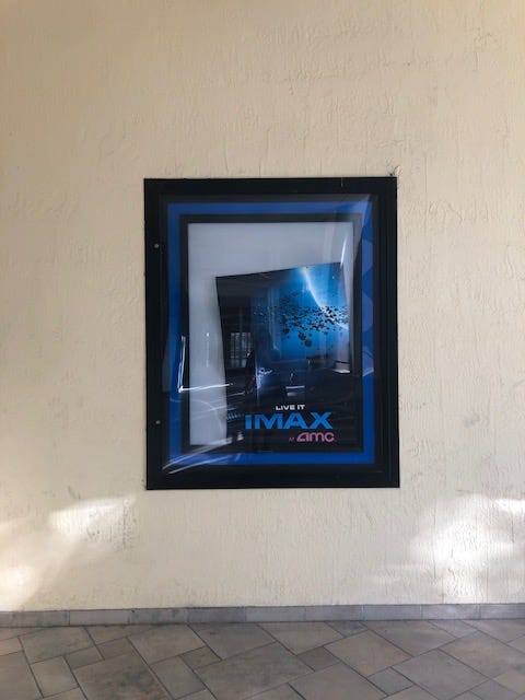 An IMAX poster falling out of its frame.
