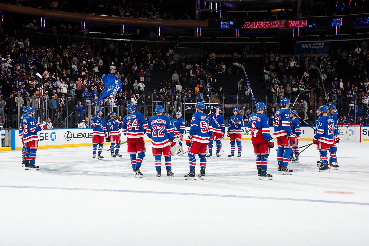 New York Rangers raising their sticks to their fans to salute them.