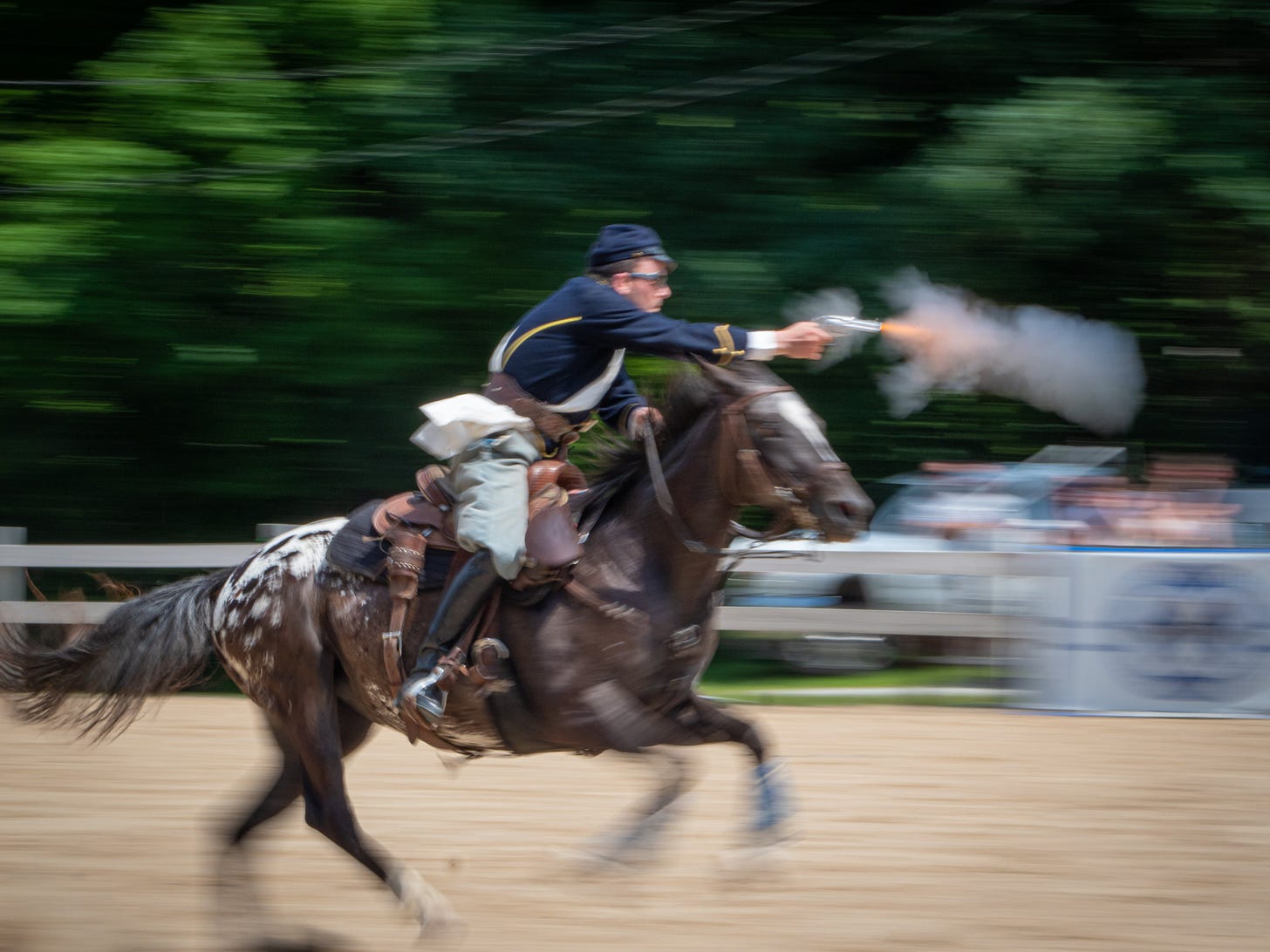 Man on horseback firing a six shooter