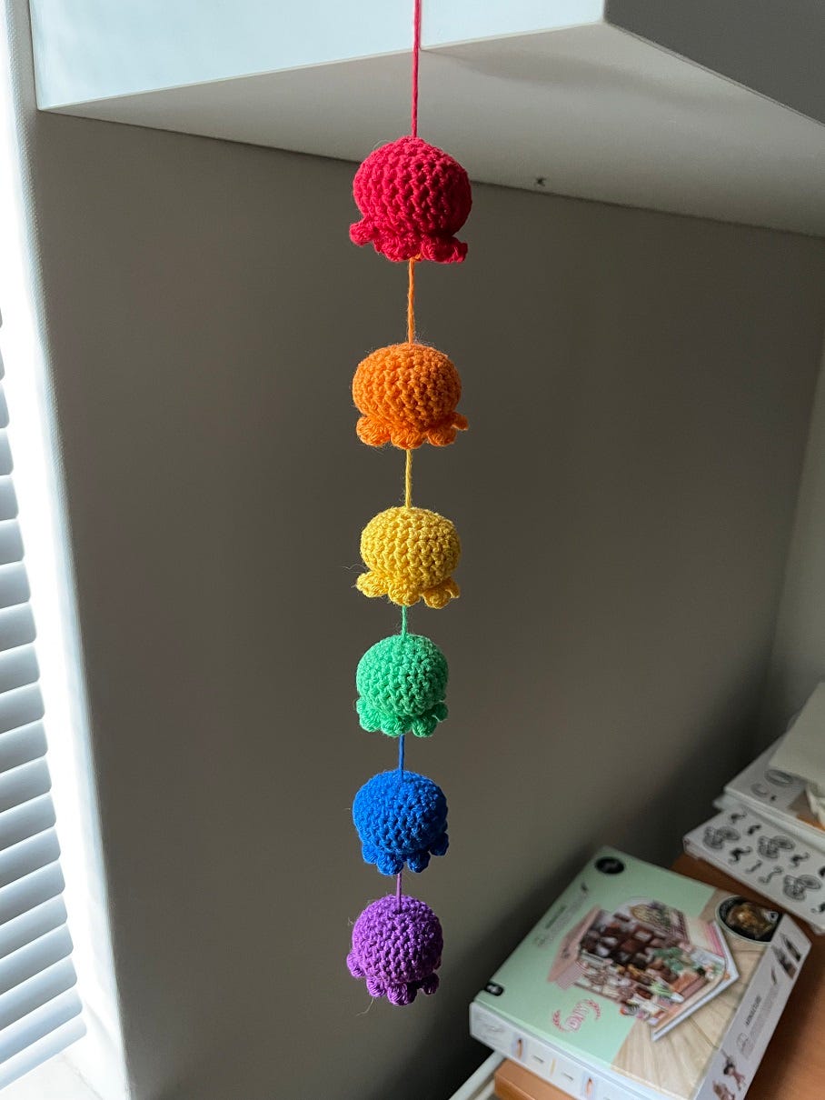 Photo of crocheted octopi in different colours, tied together on a string