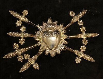 This may contain: an ornate gold brooch with heart surrounded by crosses