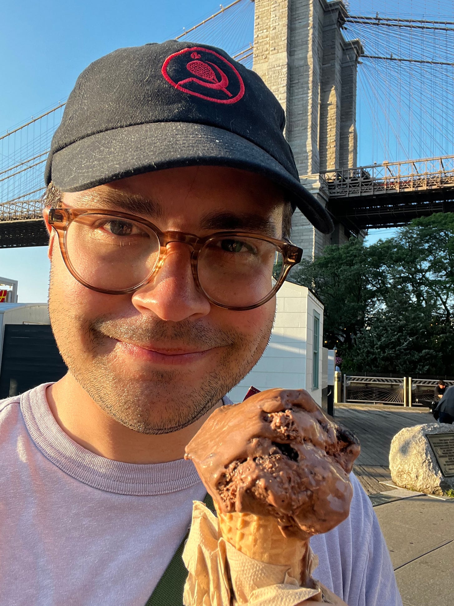 Author holding ice cream cone in front of bridge. Author holding ice cream cone in front of bridge.