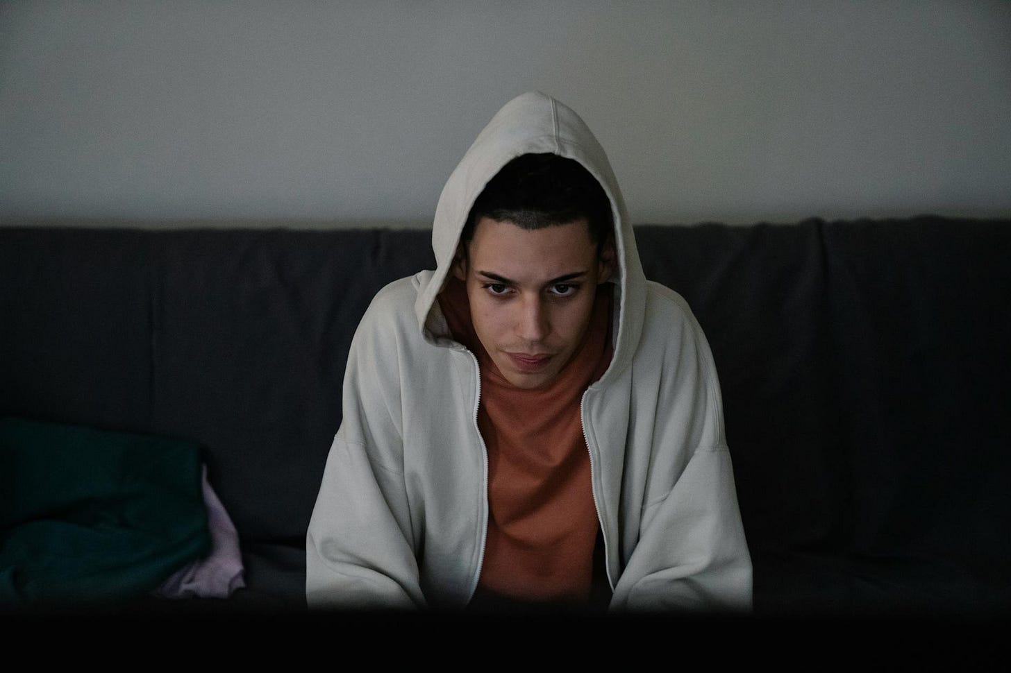 https://www.pexels.com/photo/focused-ethnic-man-in-hoodie-on-couch-in-house-7241445/