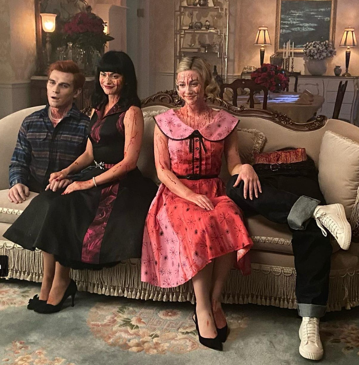 An image of Archie Andrews, sawed in half, with a bloody Veronica and Betty sitting on a couch and smiling.