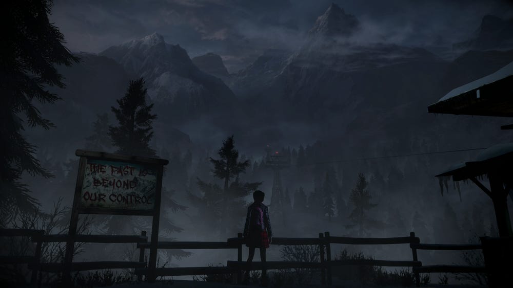 A screenshot from Until Dawn, showing a woman's figure silhouetted against the backdrop of a craggy mountain in the Canadian Rockies. A graffiti-ed sign nearby reads THE PAST IS BEYOND OUR CONTROL