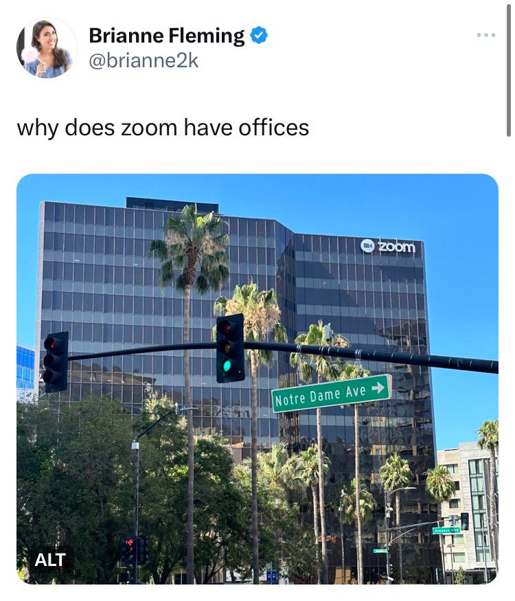 A tall glass building where Zoom is headquartered surrounded by palm trees and a street light on Notre Dame Ave