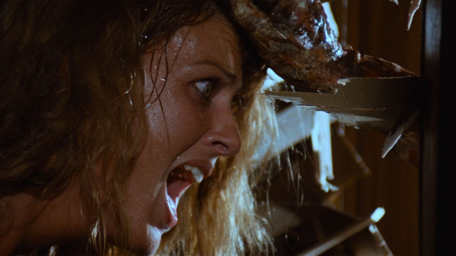 Zombie | Still features a woman whose head is being pulled towards a wood splinter.