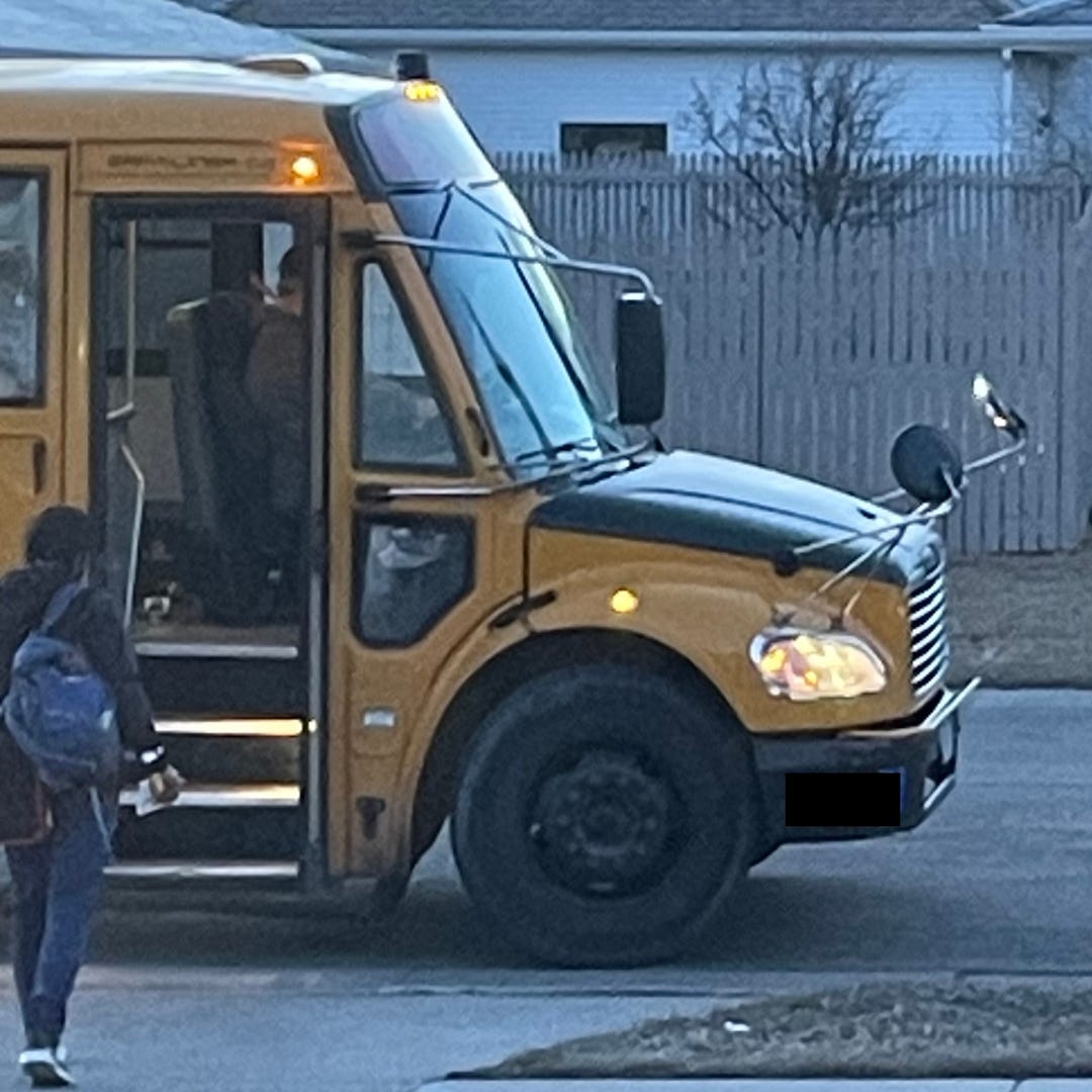 A young man walks toward a school bus