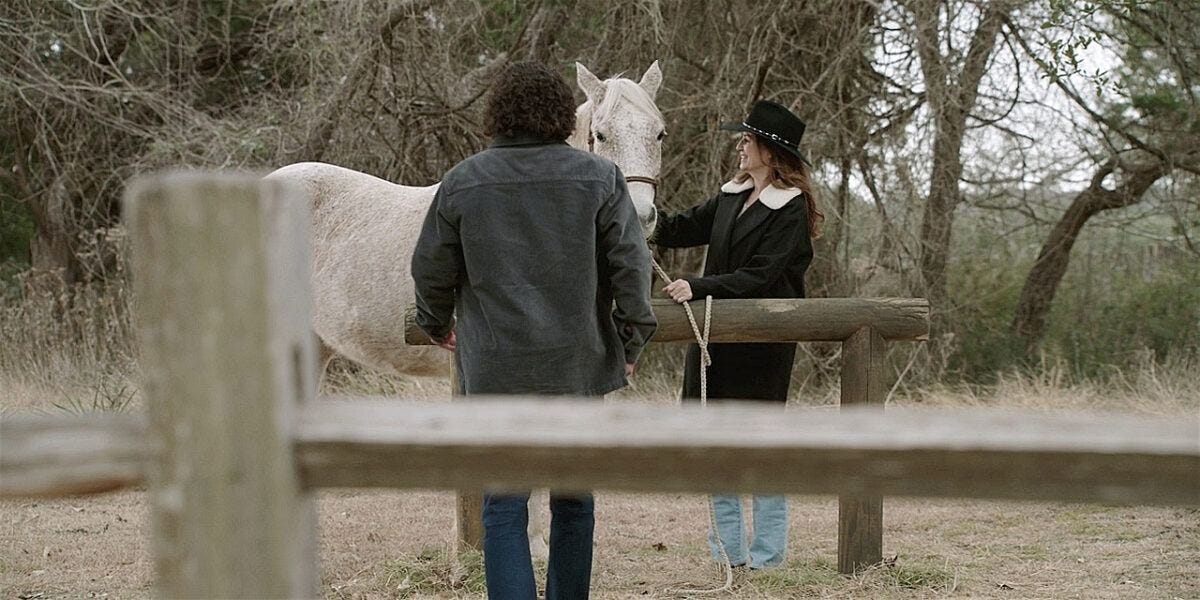 Colton hungrily looking at Denise's white stallion on Walker.