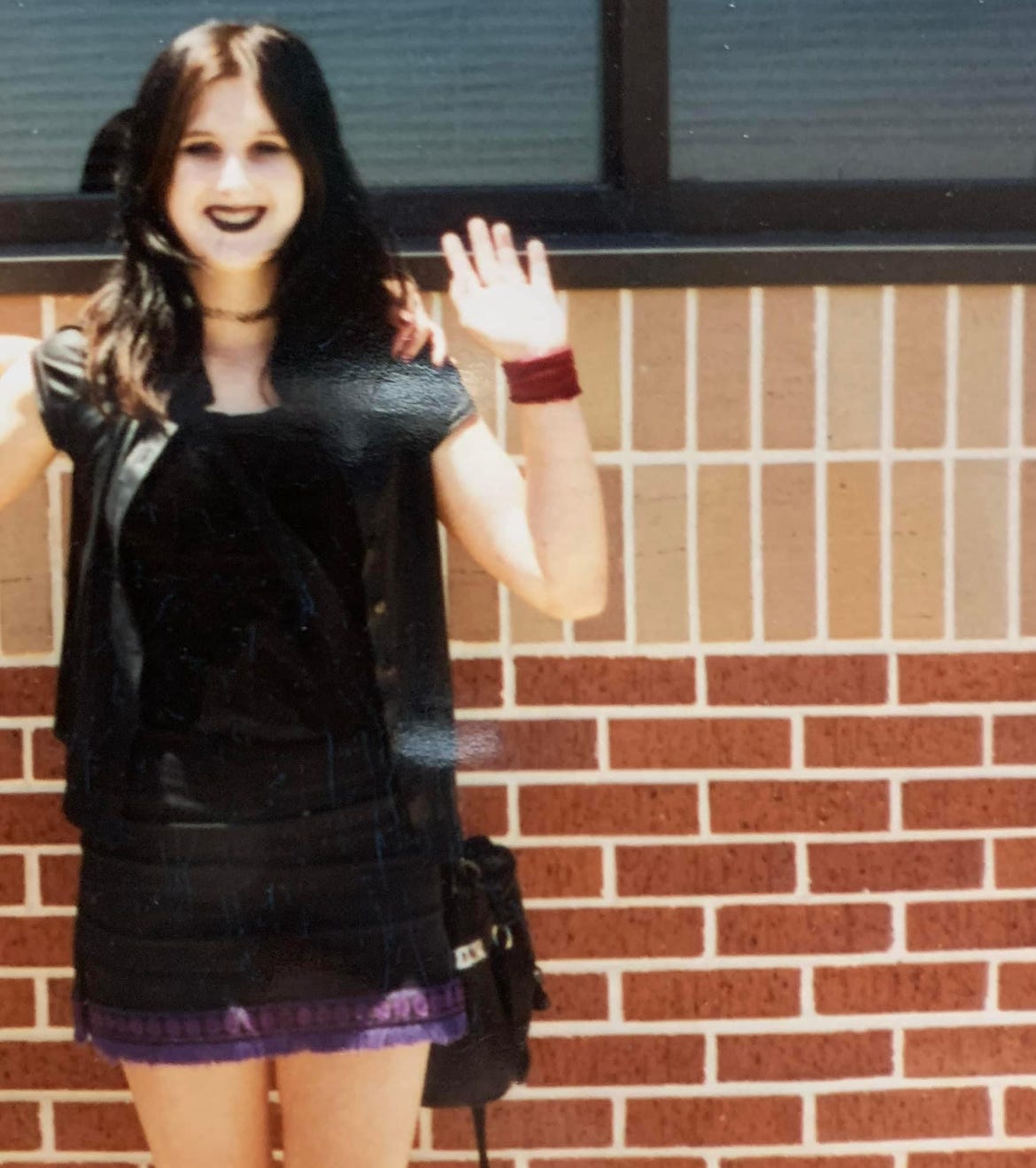 Lyric in 8th grade, in their goth vampire attire, black lipstick and face painted white. 