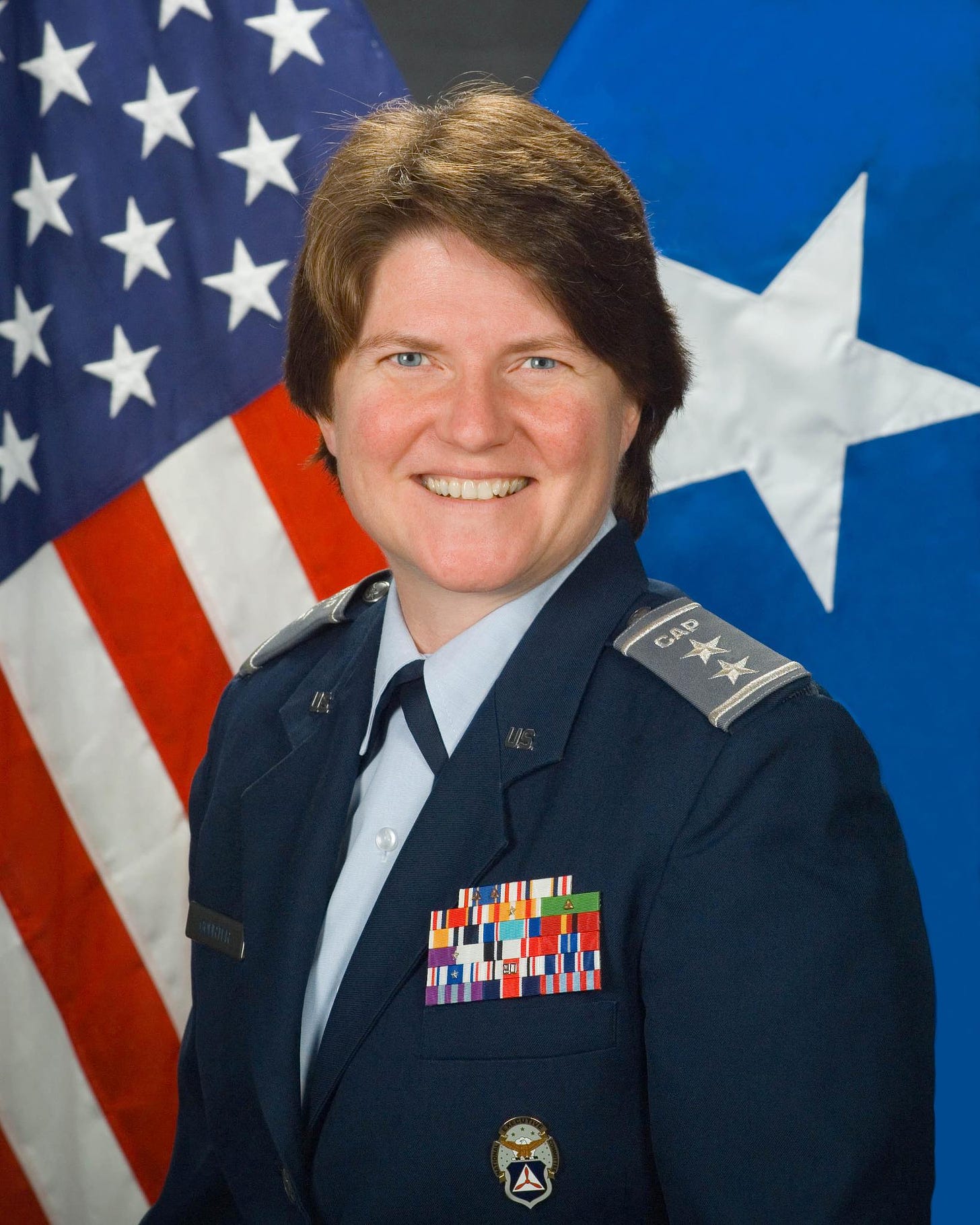 A woman standing in front of an American flag in an Civil Air Patrol two-star general uniform