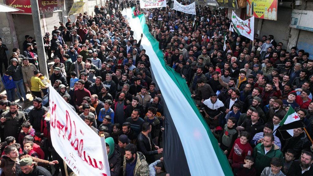 People take part in a protest against Hayat Tahrir al-Sham (HTS) in the rebel-held town of Binnish, Idlib province, north-western Syria (8 March 2024)