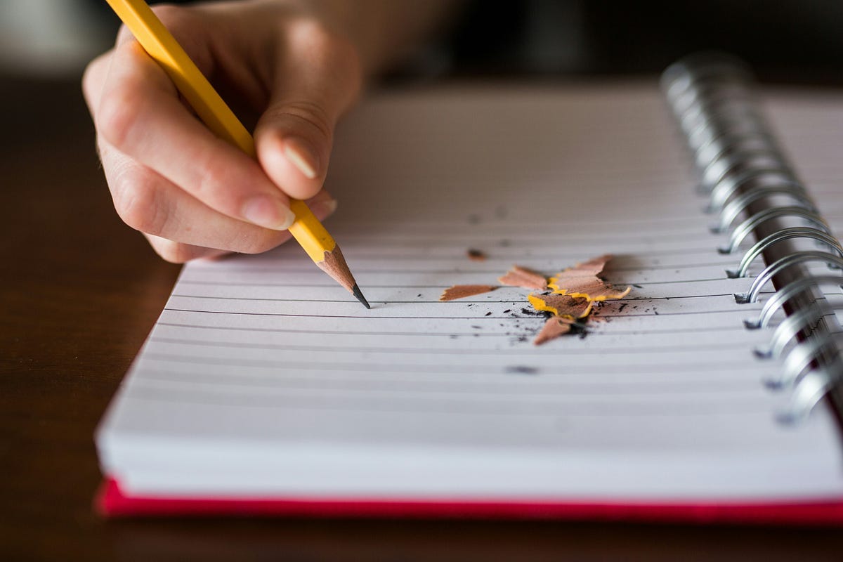 Person writing in a journal Person writing in a journal