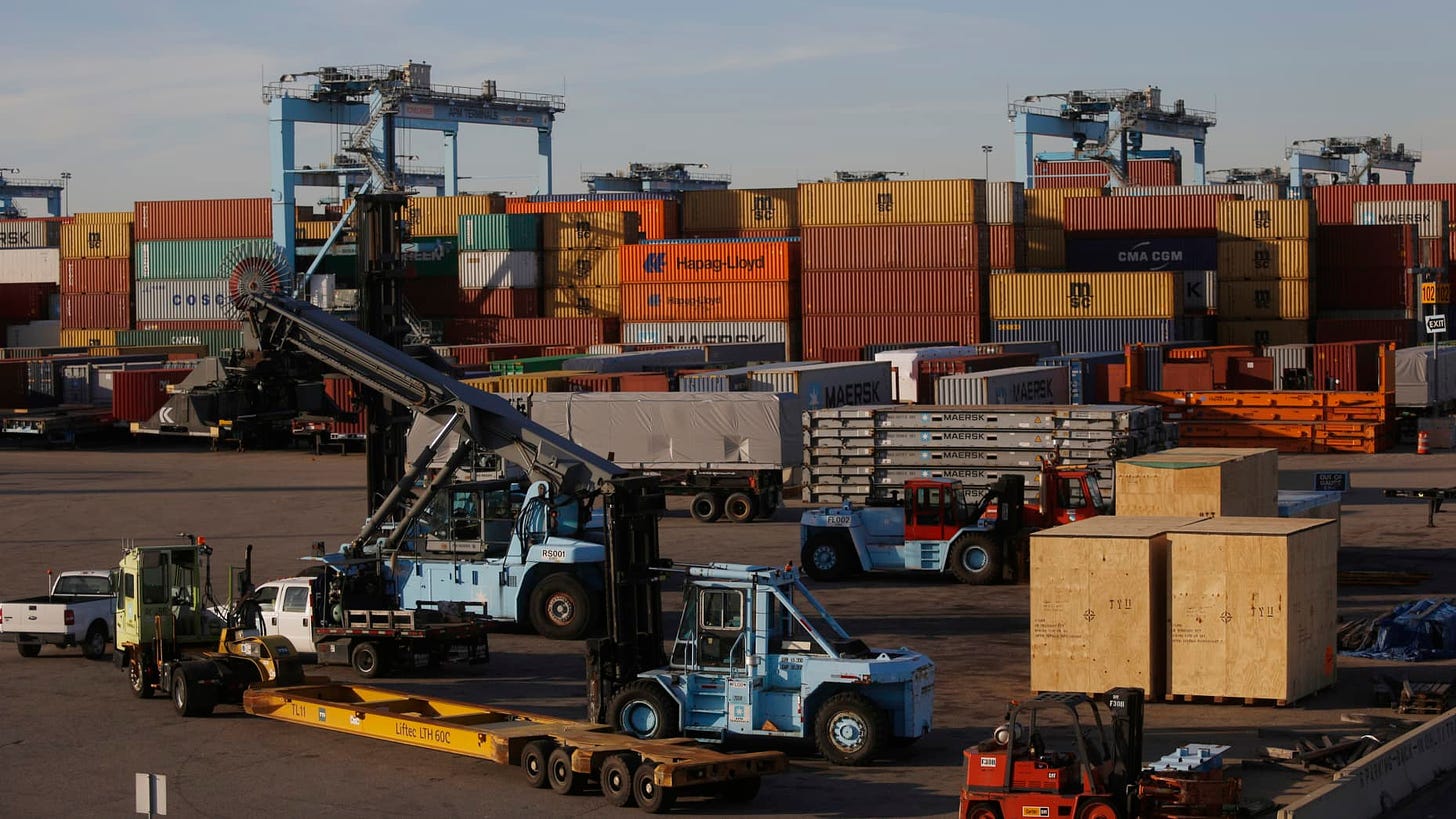 Shipping yard equipment sits parked near containers at the Port of Virginia APM Terminal in Portsmouth, Virginia, U.S., on Wednesday, Nov. 27, 2013. The trade deficit in the U.S. widened more than forecast in September to a four-month high, reflecting a pickup in imports of consumer goods and capital equipment. Exports declined for a third month. Photographer: Luke Sharett/Bloomberg via Getty Images