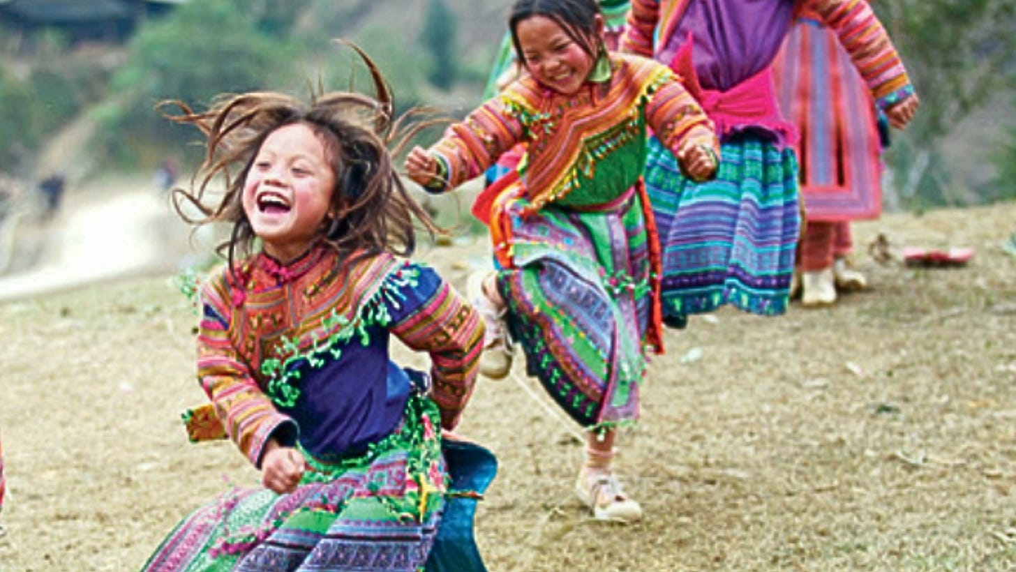 Young girls in bright clothes running and smiling