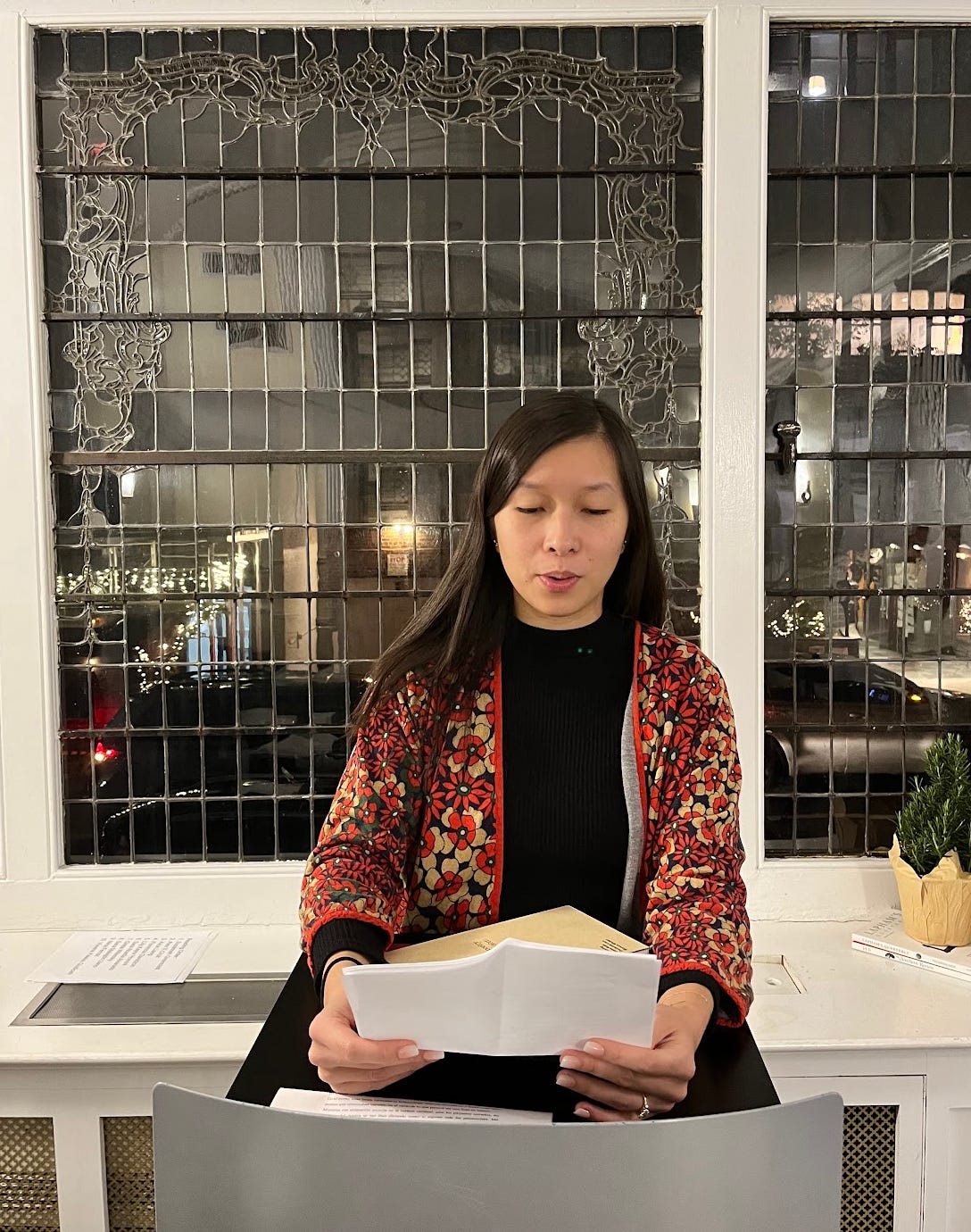 Me reading from a piece of paper at the NYU writer's house