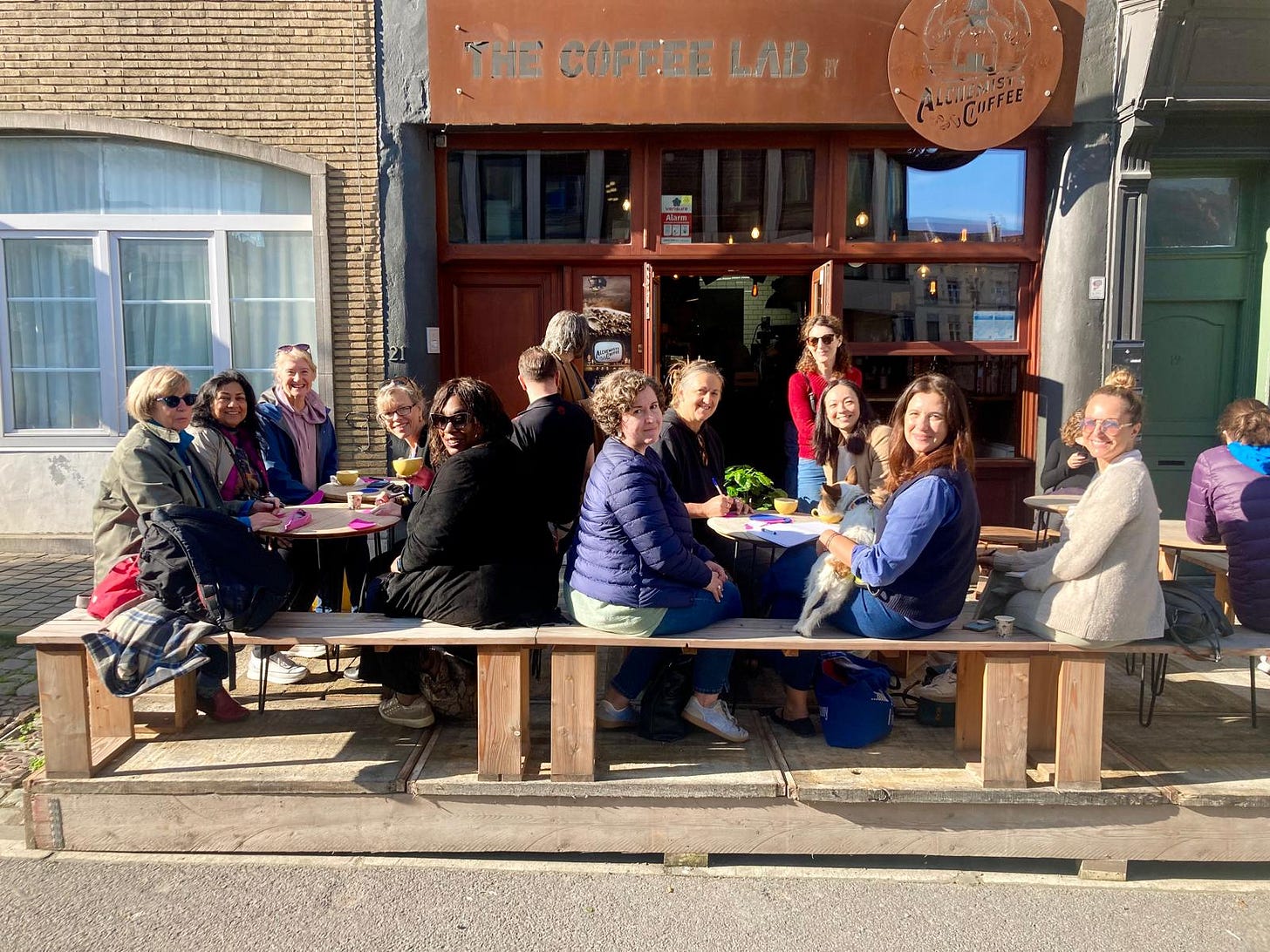 A group of writers at picnic tables outside a cafe in Brussels