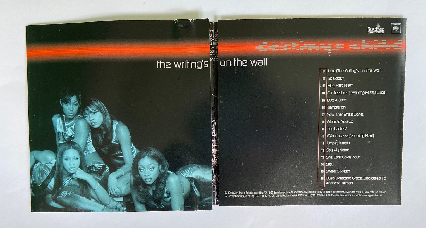 the folded booklet for The Writing's on the Wall by Destiny's Child. four young Black women pose next to each other on a black background. The album's tracklist is on the opposite page.