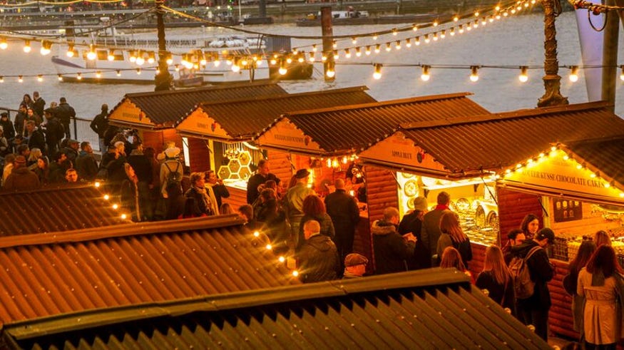 Wooden cabins with fairy lights next to the river