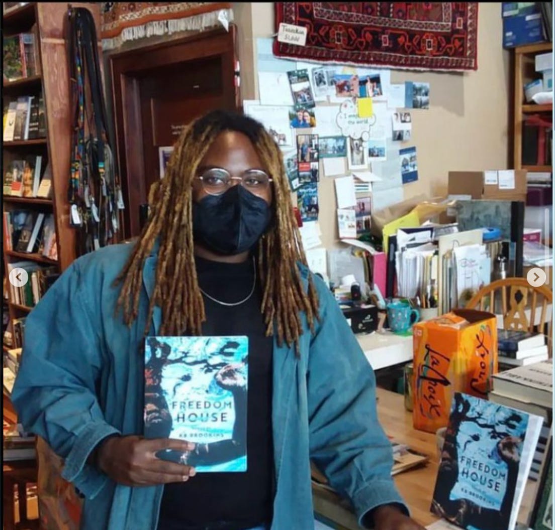 image of KB holding up a copy of FREEDOM HOUSE.