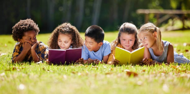 group of kids reading in the grass
