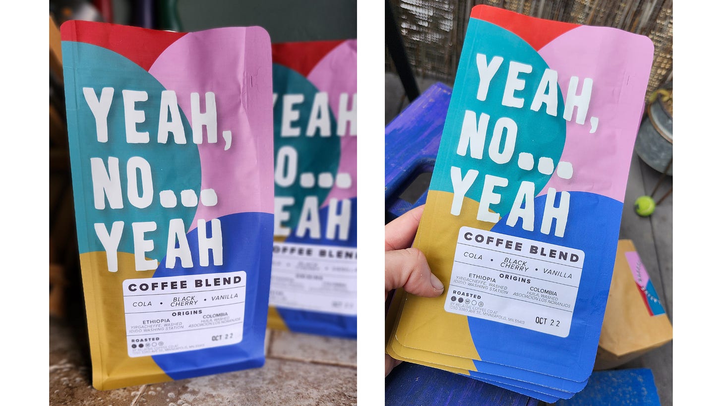 Close ups of a brightly colored coffee bag sitting on a countertop. Blue, pink, red, teal, and gold circles overlap underneath the coffee's name in a handwritten font—Yeah, No...Yeah.