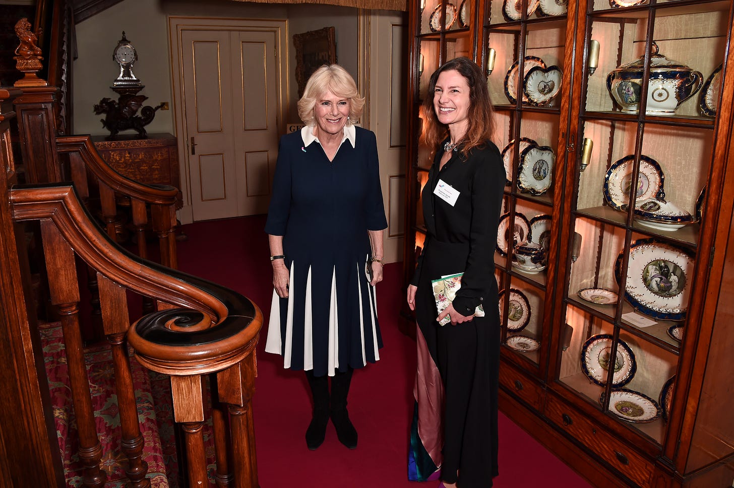 Queen Camilla standing by some stairs with SafeLives CEO Suzanne Jacob 