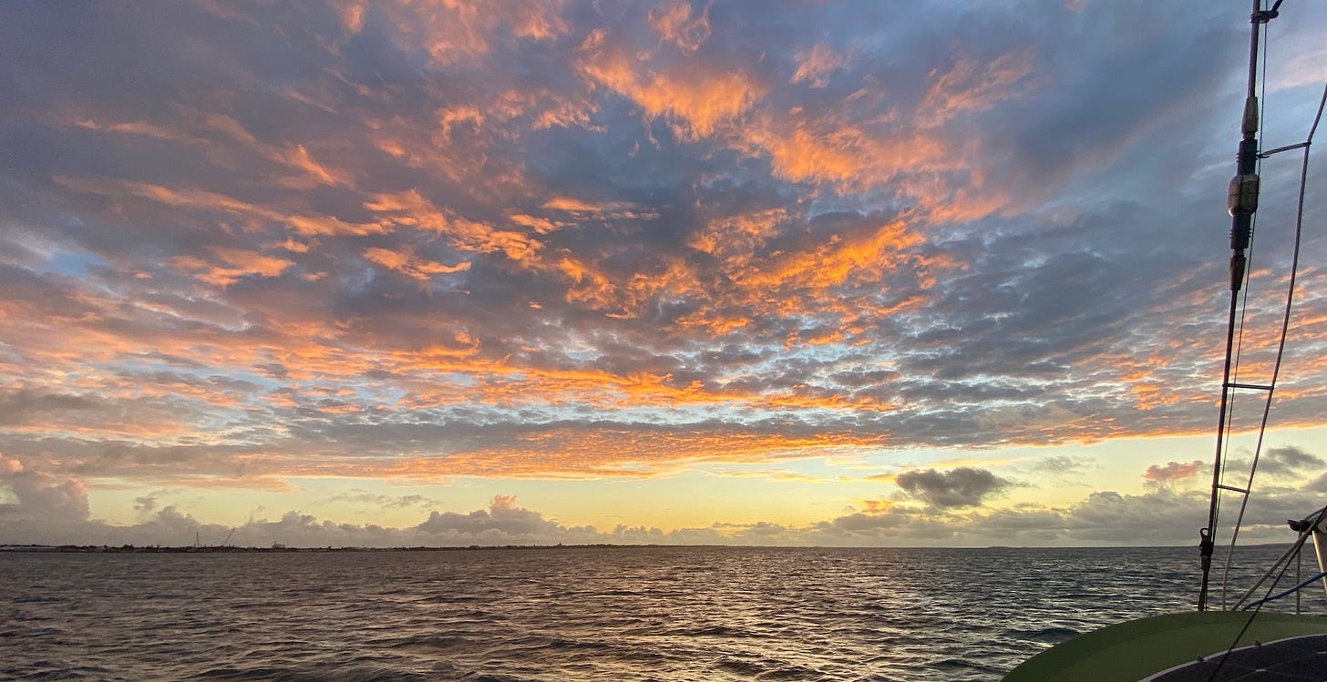 A sunset with orange clouds and a golden horizon