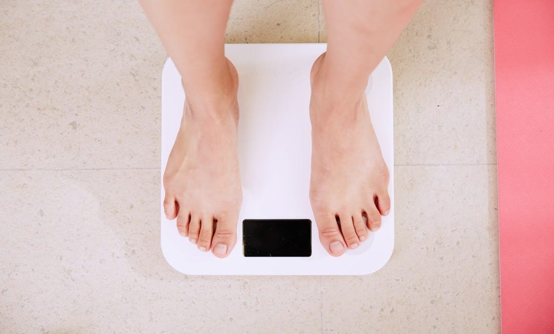 person standing on white digital bathroom scale